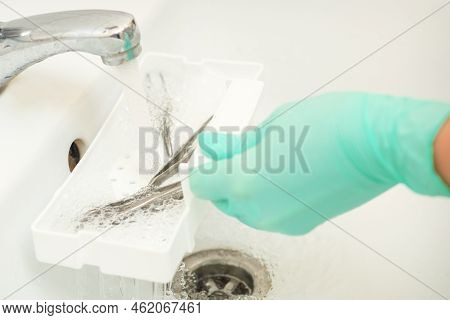 Hand In Glove Cleans The Tweezers With Water In-tray. Cleaning Systems For Tweezers