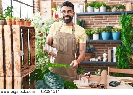 Young arab man florist using difusser working at florist