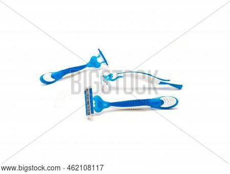 Three Brand New Blue And White Plastic Disposable Razors With Ergonomic Handle Isolated On White Bac