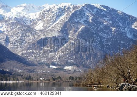 Bohinj, Slovenia, Eu - February 28, 2021: View From Lake Bohinj To Mountain Komna, With Some People 