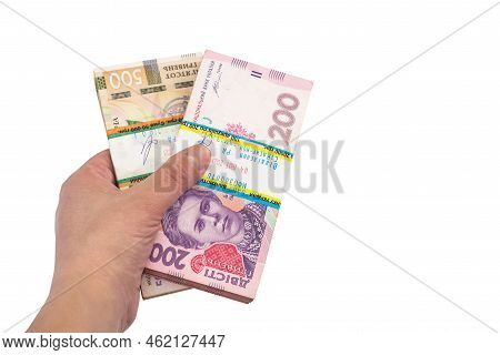 Close-up Of A Hand And Packs Of Ukrainian Hryvnias On An Isolated White  Background