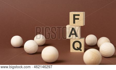 Faq - Frequency Asked Questions - Letter Pices On The Wooden Cubes, Brown Background.