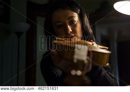 Young Woman Apprentice Violinmaker Checking Her Violin