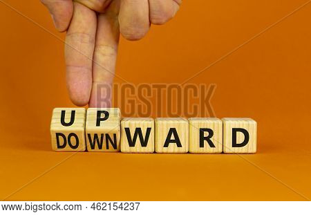 Upward Or Downward Symbol. Businessman Turns Wooden Cubes And Changes The Word 'downward' To 'upward