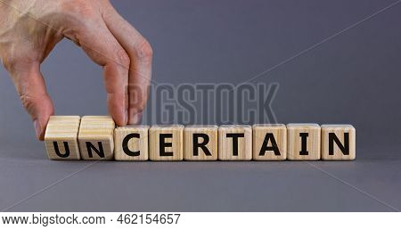 Certain Or Uncertain Symbol. Businessman Turns Wooden Cubes And Changes The Concept Word Uncertain T