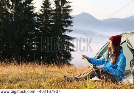 Woman Working On Laptop Near Camping Tent Outdoors Surrounded By Beautiful Nature