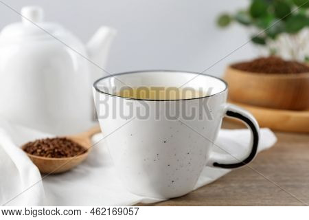 Buckwheat Tea In Cup And Spoon With Granules On Wooden Table, Closeup