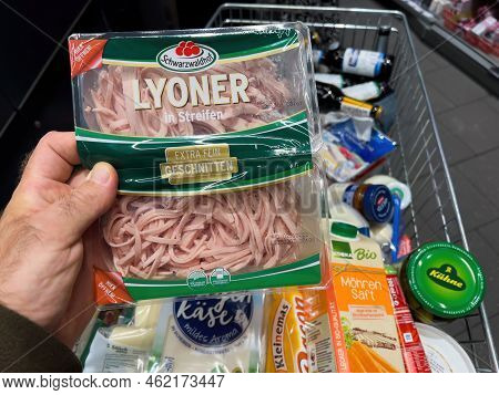 Frankfurt, Germany - Sep 17, 2022: Pov Male Hand With Lyoner Meat For Salad Above A Full Shopping Ca
