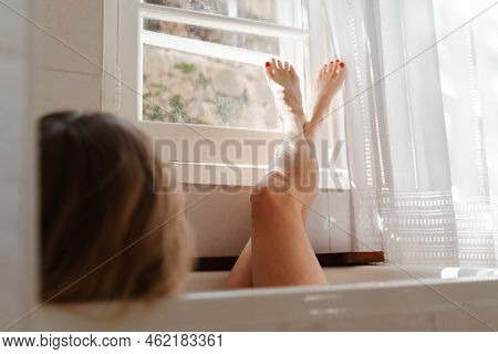 A Beautiful Mature Woman Massages Her Legs In A Bath With Candles In A Cozy And Comfortable Atmosphe