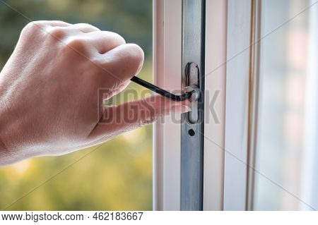 Adjusting The White Plastic Window. A Worker Uses A Hexagon To Repair A Window.