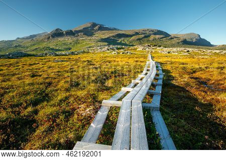 Wooden Walk Leading Across Marshlands To Nieras Massive In The Stora Sjofallet National Park, Sweden
