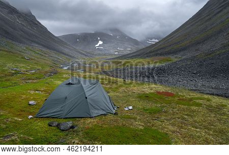 Green Outdoor Tent Pitched In Harsh, Remote Arctic Valley On A Cloudy, Rainy Day Of Summer. Basstava