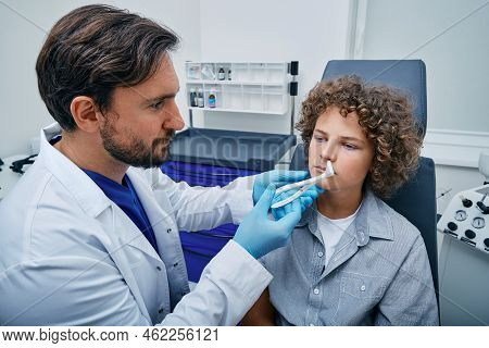 Ent Using Nasal Speculum Or Rhinoscope To Examine Child Patients Nose Area. Curly Boy While Rhinosco