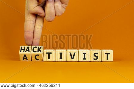 Activist Or Hacktivist Symbol. Businessman Turns Wooden Cubes And Changes The Word Activist To Hackt