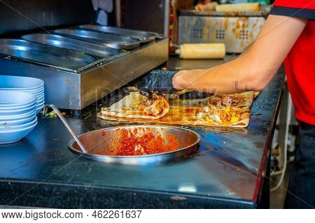 Turkish Street Food. Man Bakes Traditional Griddle-cake In Old Town Antalya, Turkey