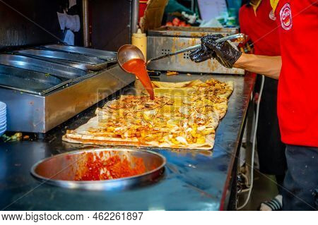 Antalya, Turkey - September 10, 2022: Turkish Street Food. Man Bakes Traditional Griddle-cake In Old