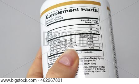 Irpen, Ukraine, August 23 20222, Woman Reads The Composition On A Jar Of Fish Oil Supplement, Omega 