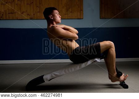 Shirtless 19 Year Old Teenage Boy Soing Situps On An Exercise Bench