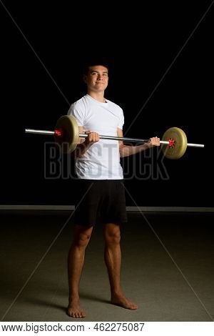 19 Year Old Teenage Boy Excercising His Biceps With A Barbell