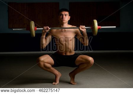A Shirtless 19 Year Old Teenage Boy Lifting A Barbell