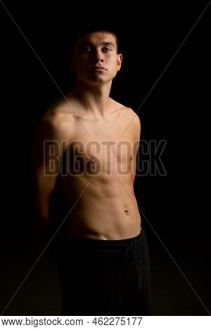 A Shirtless 19 Year Old Teenage Boy With A Black Background