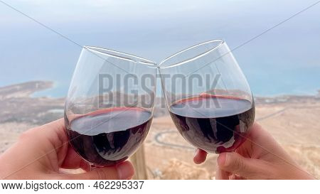Cheers. Couple Enjoying A Glass Of Wine In A Beautiful Seabackground.