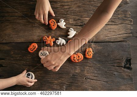 Festive Gingerbread On Halloween In Form Of Pumpkins, Ghosts And Ginger Man In Childrens Hands On Wo