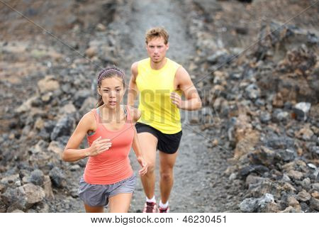 Par de corredores en pista en cross country ejecuta entrenamiento al aire libre en Hawaii, grande Isla mar