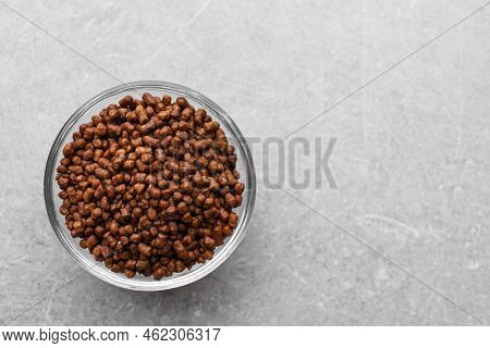 Buckwheat Tea Granules In Glass Bowl On Light Grey Table, Top View. Space For Text