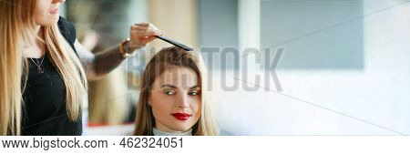 Portrait Of Hairdresser Using Comb To Brush Clients Hair, Woman On Appointment In Salon. Professiona