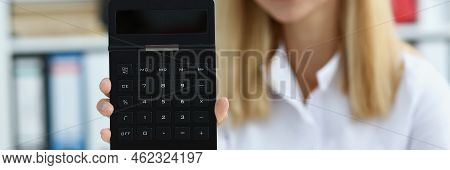 Portrait Of Smiling Businesswoman Accountant Holding Calculator In Hand Demonstrates Display Countin