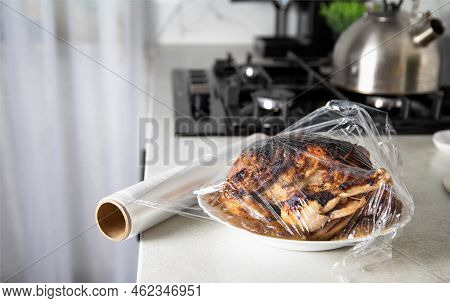 A Plate With Fried Chicken Wrapped In Cling Film In The Kitchen, Close-up. Storing Food In The Refri