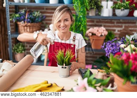 Young blonde woman florist using difusser working at florist