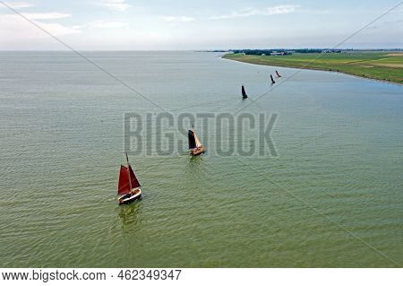 Aerial From Traditional Dutch Wooden Boats At The Ijsselmeer Near The Harbor From Laaxum In Frieslan