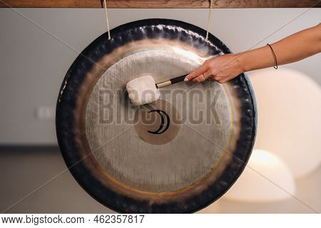 Close-up Of A Woman's Hand Pounding A Gong With A Hammer. Gong And Hand Beater For Gong