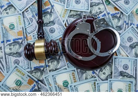 Judge's Gavel With Handcuffs On The Background Of Dollar Bills.