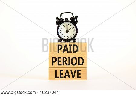 Paid Period Leave Symbol. Concept Words Paid Period Leave On Wooden Blocks. Black Alarm Clock. Beaut