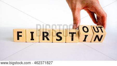 First In First Out Symbol. Businessman Turns Wooden Cubes And Changes Words First In To First Out. B