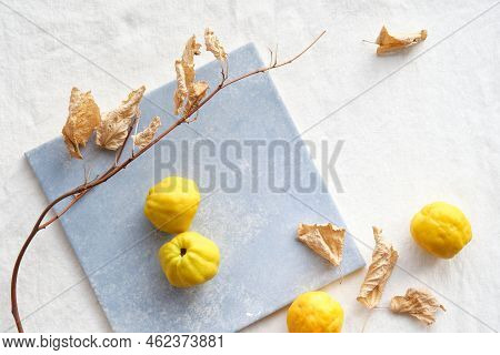 Colorful Autumn Pattern With Yellow Quince Fruits On Blue Ceramic Tile. Seasonal Fall Still Life Arr