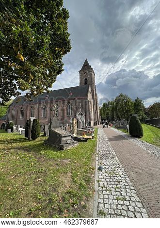 Bellem , East-flandres, 09 18 2022 : A Wide Angle View On The Catholic Church With A Walkway Along T