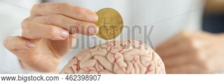 Close-up Of Businesswoman Holding Bitcoin Coin In Front Of Human Brain. Smart Part Of Human Body, Cr