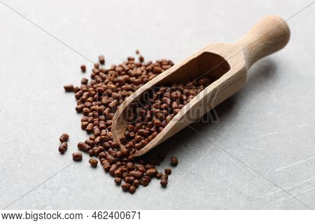 Scoop With Buckwheat Tea Granules On Light Grey Table, Closeup