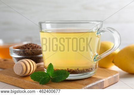 Cup Of Aromatic Buckwheat Tea, Mint And Granules On White Table, Closeup