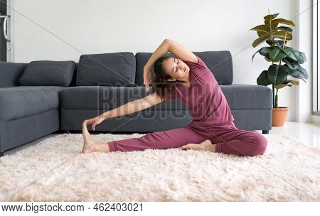 Asian Housewife Practicing Yoga And Doing Revolved Head To Knee Forward Exercise During Home Workout