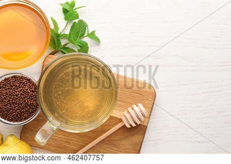 Cup Of Aromatic Buckwheat Tea, Granules, Mint And Honey On White Wooden Table, Flat Lay. Space For T