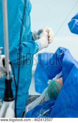 Crossed Fingers Of A Surgeon In Sterile Gloves. Selective Focus. The Surgeon Stands Over The Patient