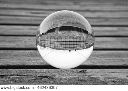 Glass Ball On A Wooden Pier At A Swedish Lake At Dusk In Black And White. Nature Shot From Scandinav
