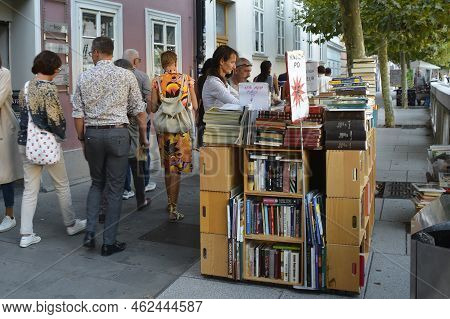 Ljubljana, Slovenia - September 3rd 2022. Passersby Stop To Look At Books Outside A Book Shop In Cen