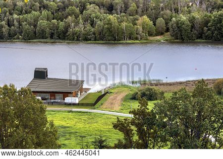 Estonia, Viljandi, September, 2022: Small Summer Wooden Cottage On The Lake Shore With Dense Forest 