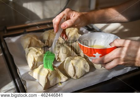 Making Apples Baked In Dough. Closeup Of Woman's Hands Spreading Egg Yolk With Silicone Culinary Bru